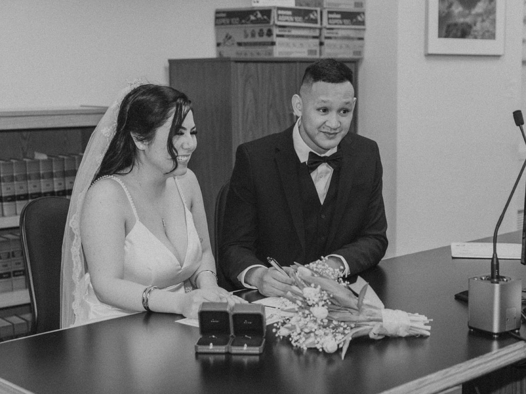 bride and groom signing marriage certificate at king county courthouse in seattle washington
