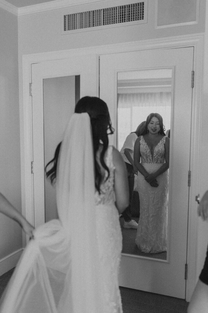 bride looking at herself in the mirror while getting ready