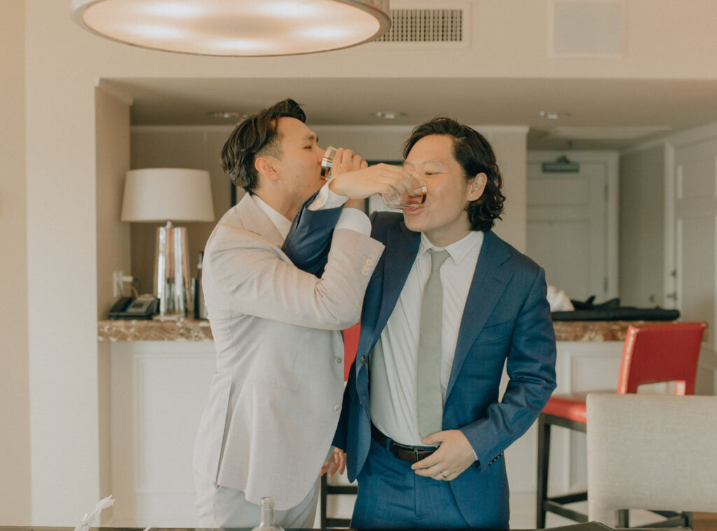 groom taking a shot of soju with his best man and officiant before the wedding ceremony