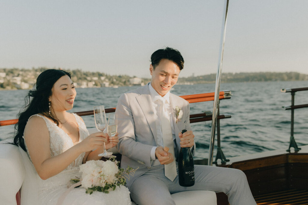 bride and groom enjoying a drink together as newlyweds on a boat