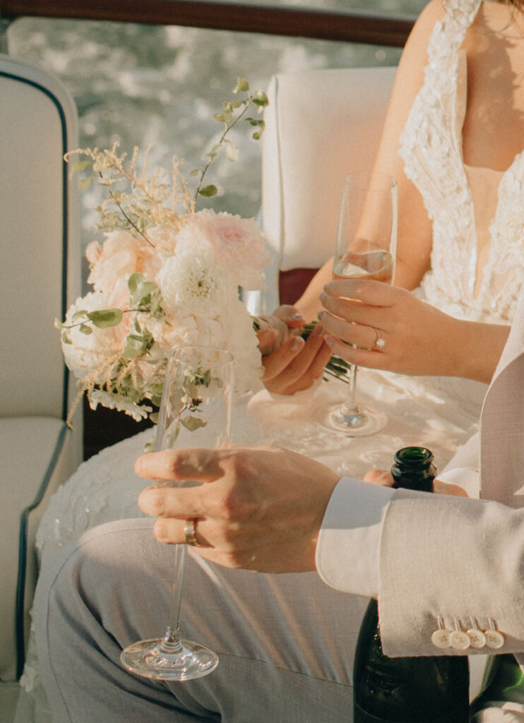 close up of bride and groom holding drinks in hand