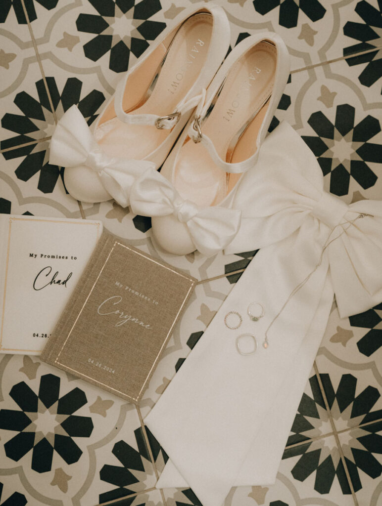 wedding shoes, vow book, and wedding bow