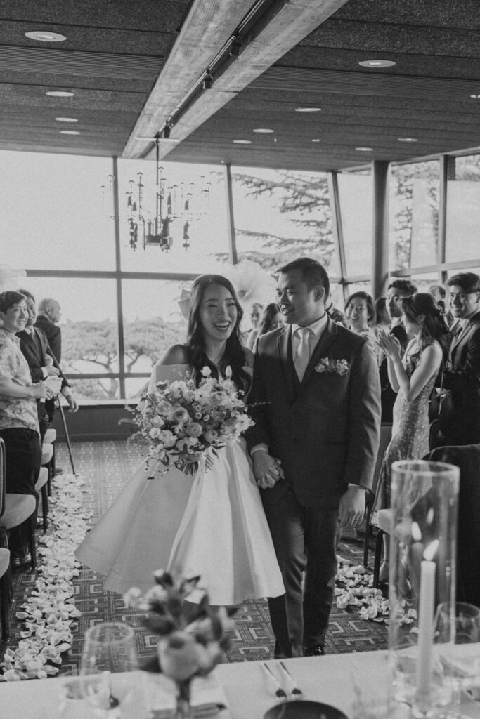 bride and groom smiling while exiting the aisle at canlis ceremony in seattle