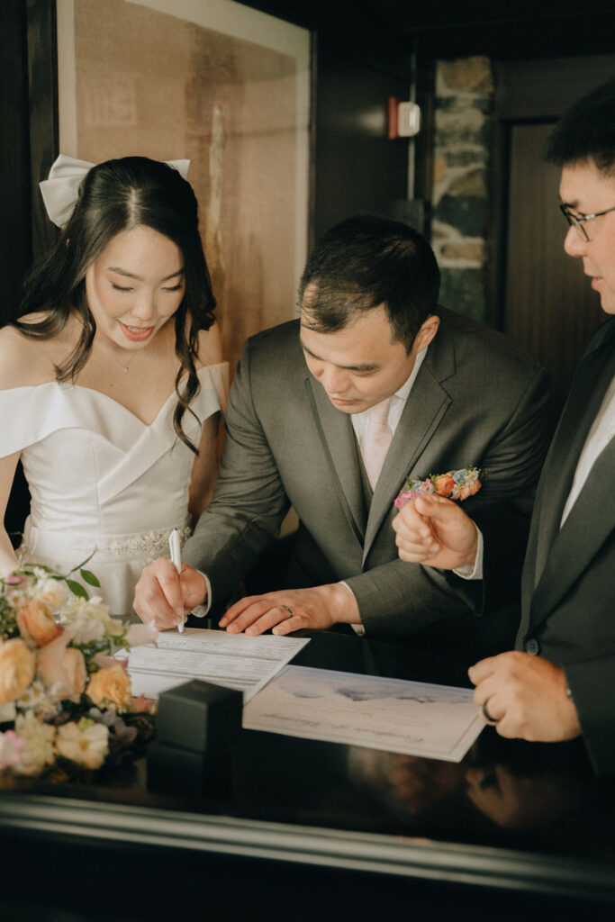 bride and groom signing marriage certificate